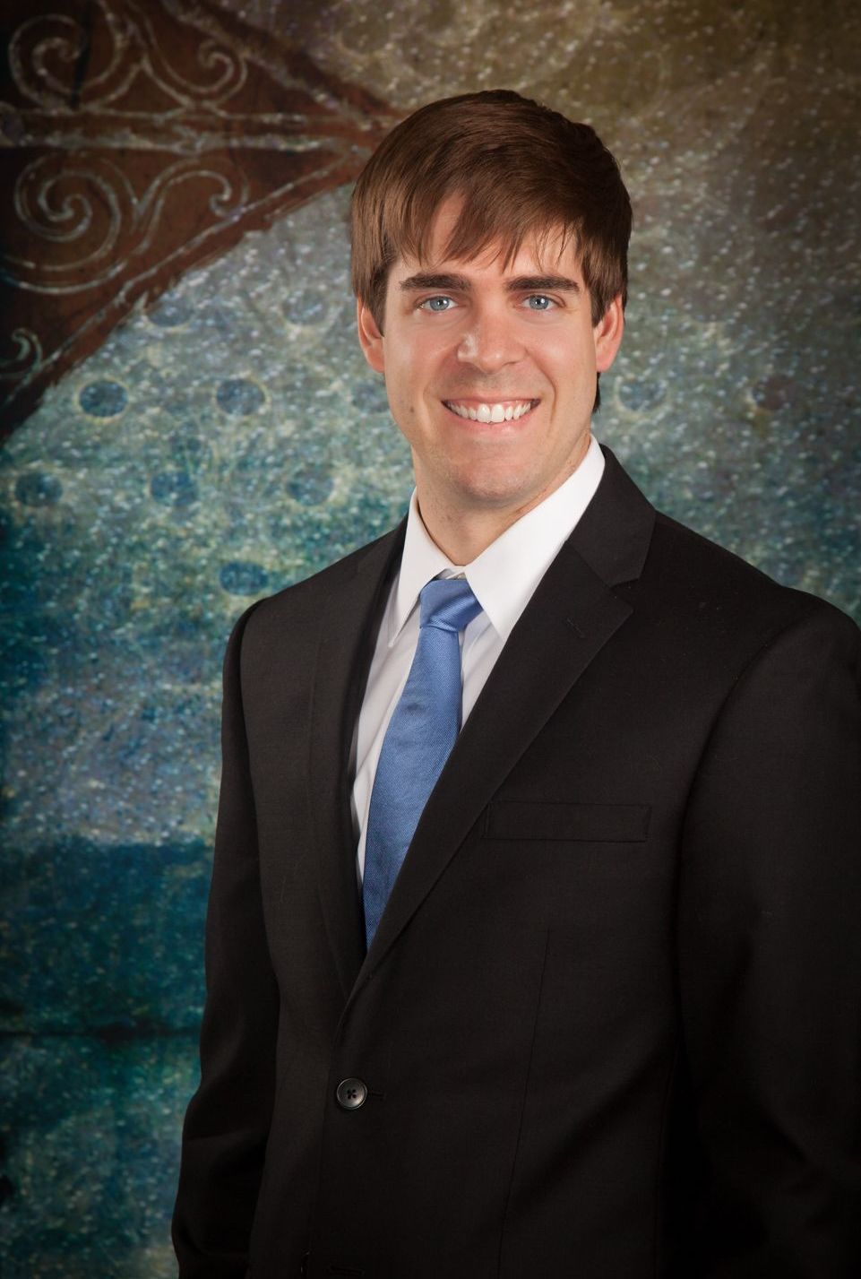 A man in a suit and tie is smiling for the camera.