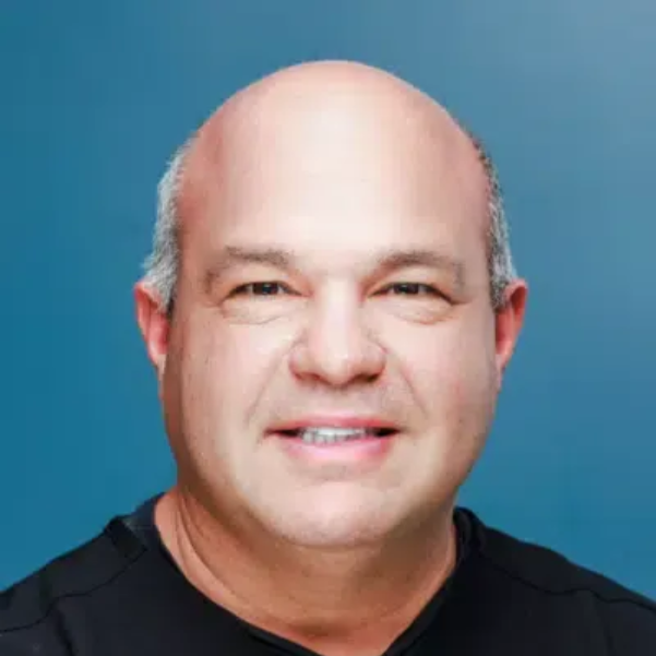 Portrait of a smiling bald man against a blue background