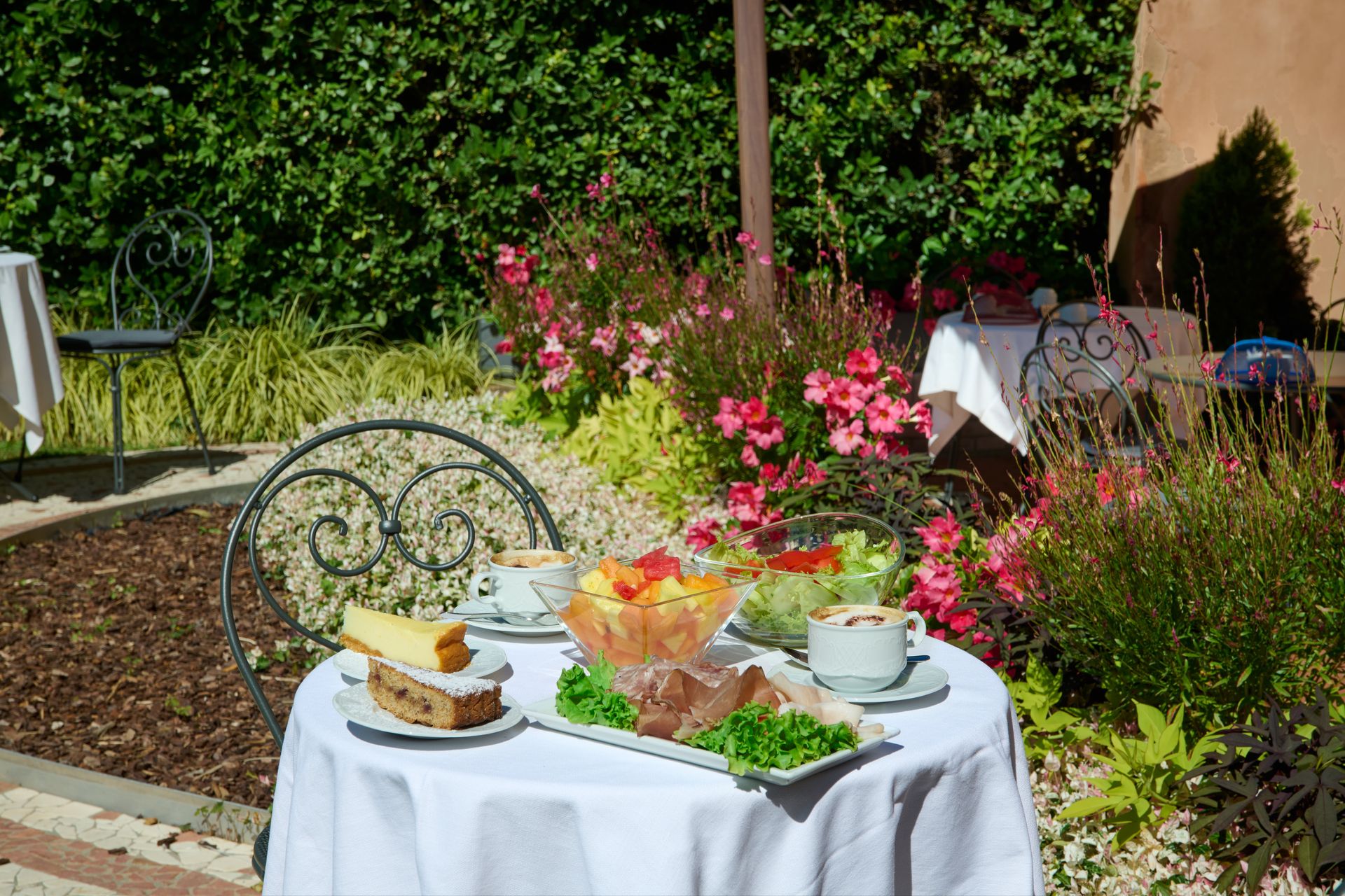 Un tavolo con un piatto di cibo sopra in un giardino.
