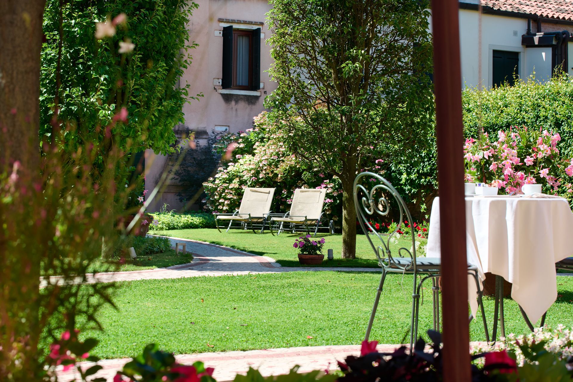 A table and chairs in a garden with a house in the background