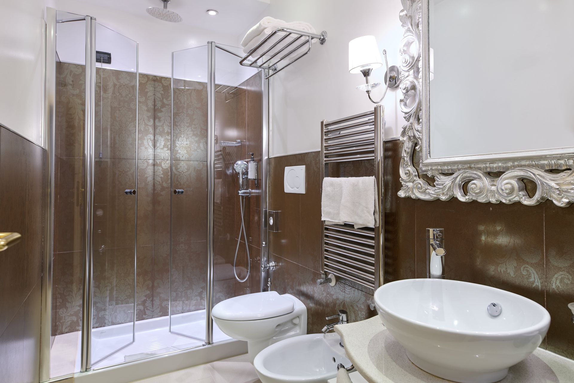 A bathroom with a sink , toilet , shower and mirror.