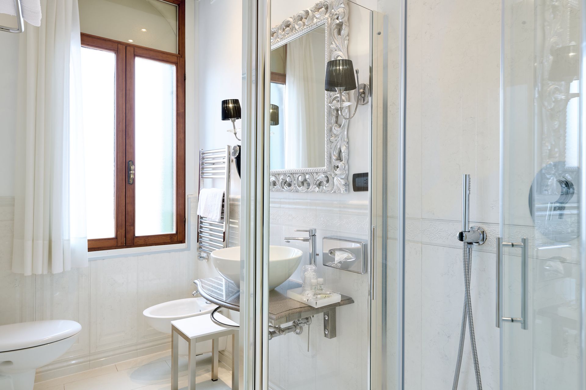 A bathroom with a toilet , sink , mirror and shower.