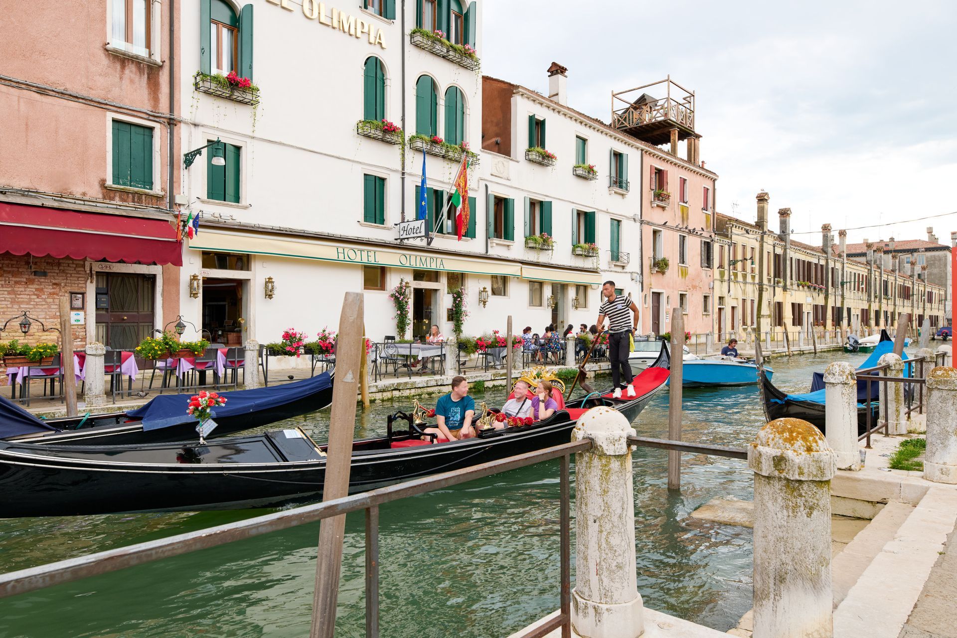 A group of people are riding a gondola down a canal.