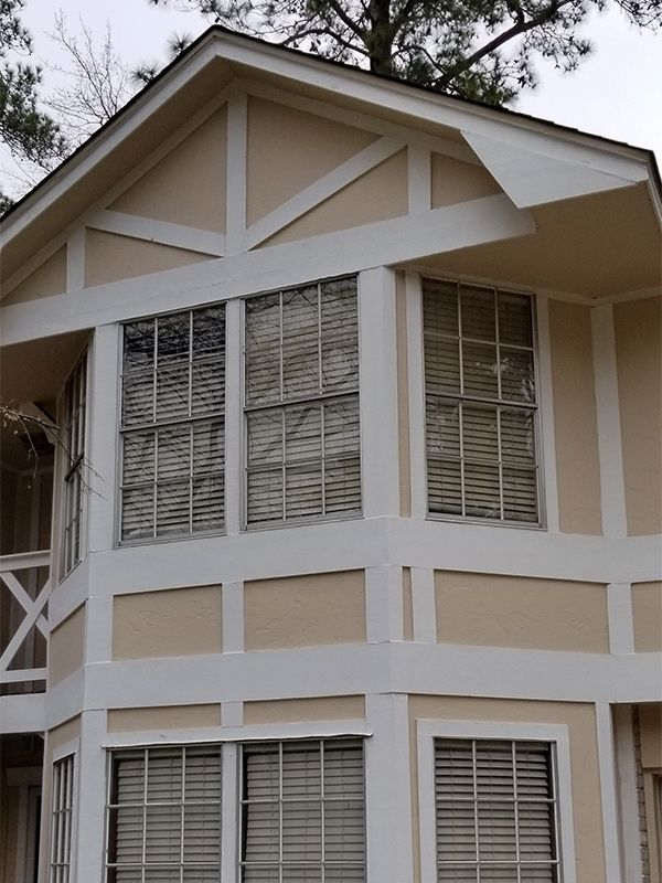 Beige house with white trim around windows.