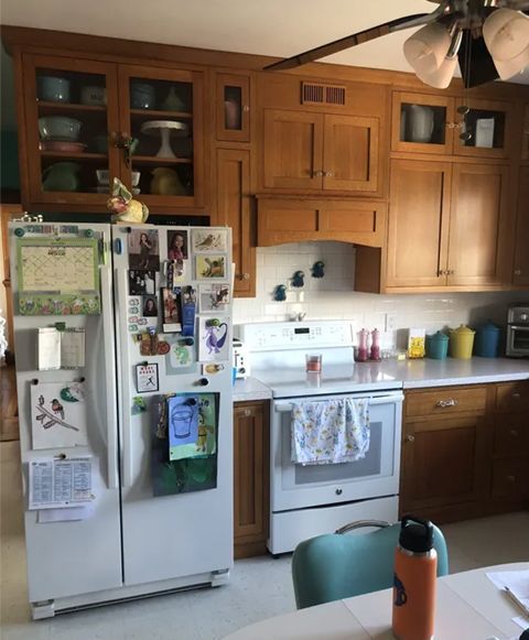 Bright kitchen with white cabinets, granite island, stainless stove, and tiled floor