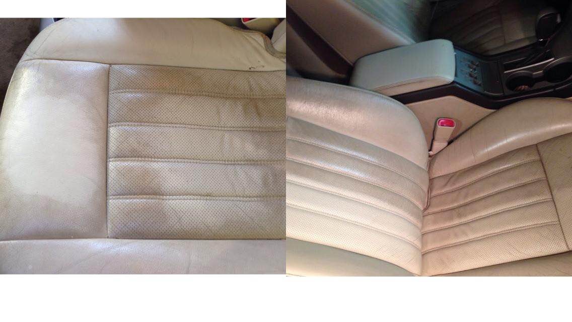 Close-up of a tan leather car seat with stitched panels and a red seatbelt latch.