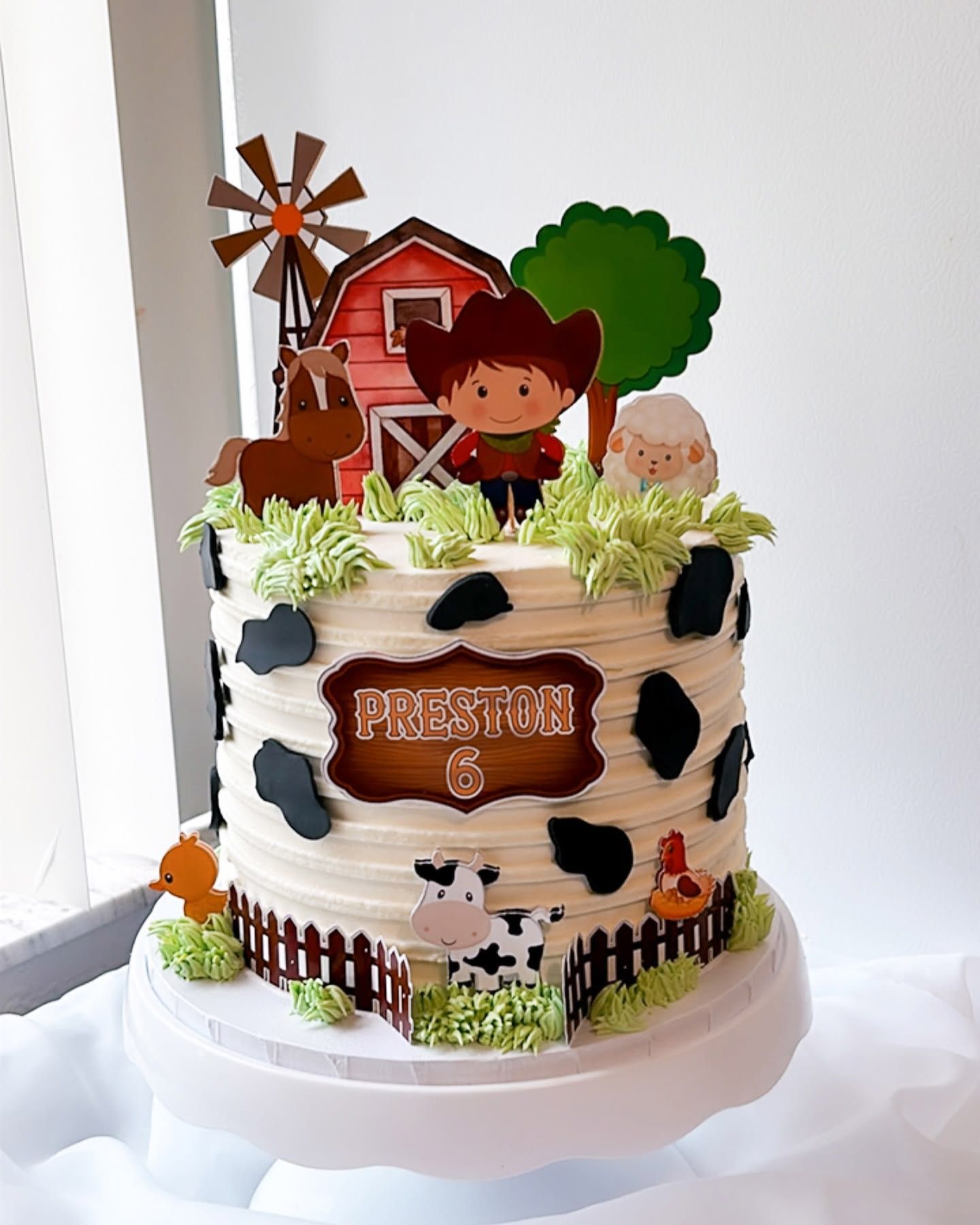A cake with a cowboy and cow on it is sitting on a table.