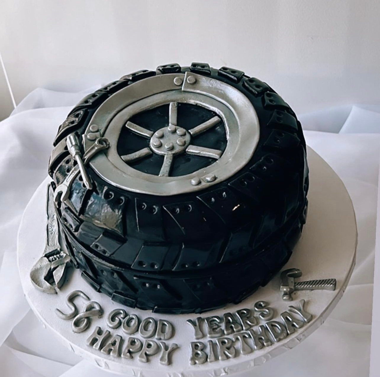 A birthday cake with a tire on it that says good years happy birthday