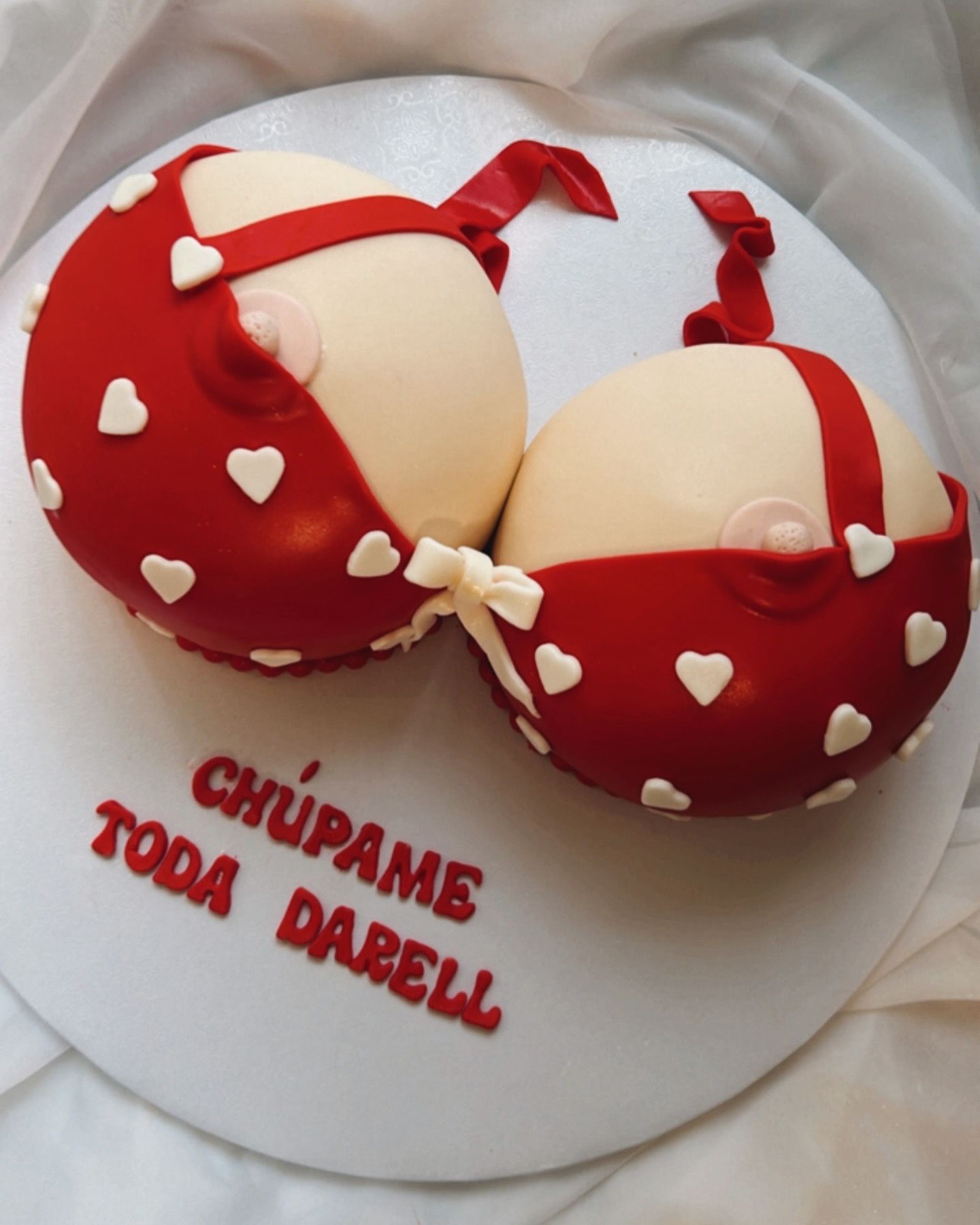 A cake that looks like a bra with hearts on it