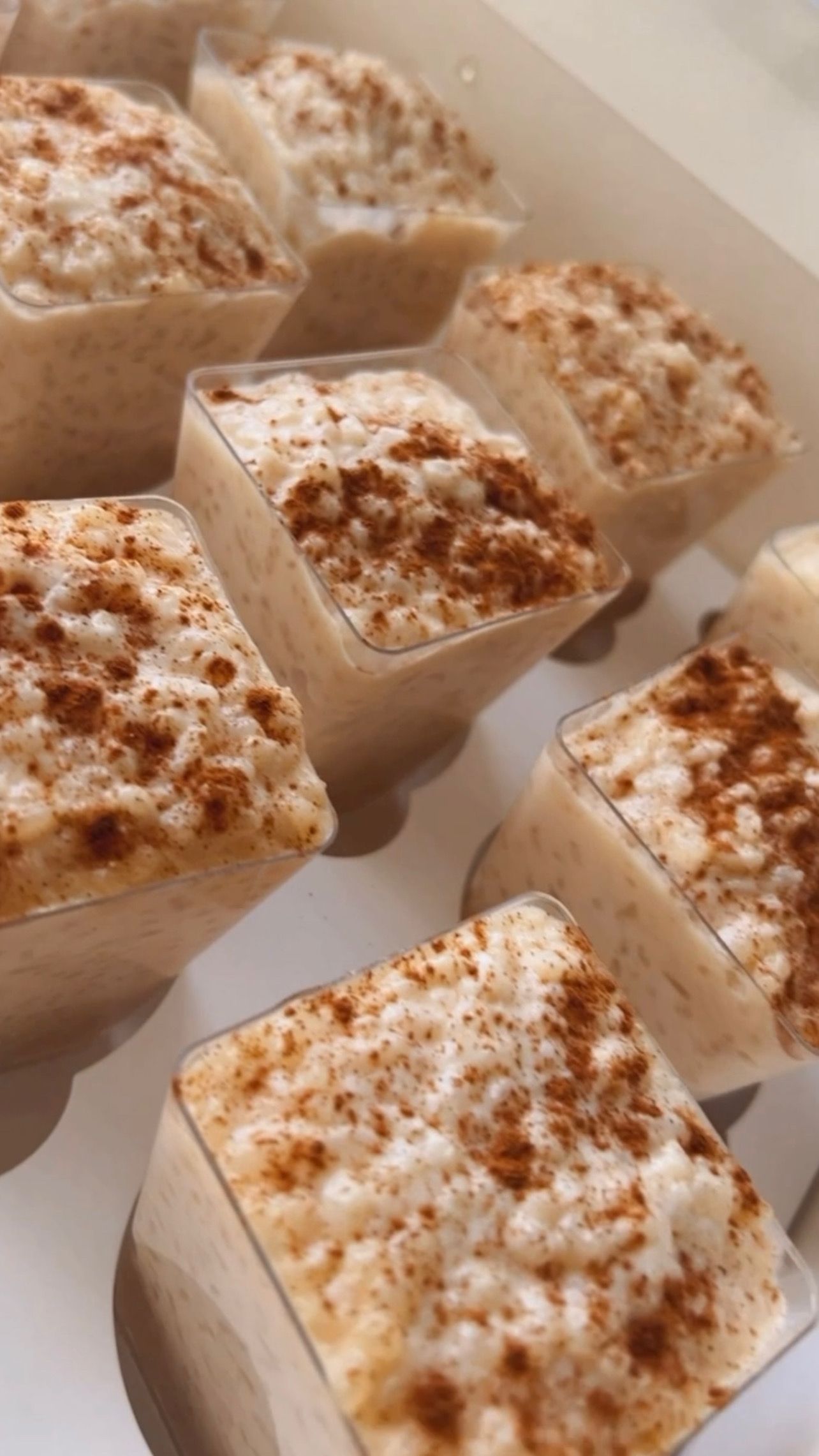 A close up of a box of desserts with cinnamon on top.