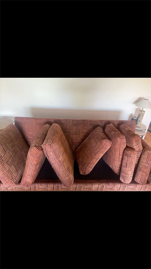 Brown patterned cushions arranged in a row on a sofa, forming a zigzag decorative display