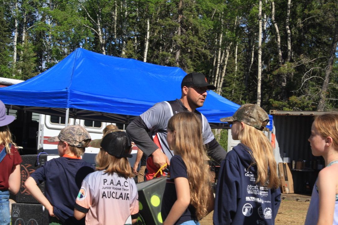 A group of people are standing in front of a blue tent.