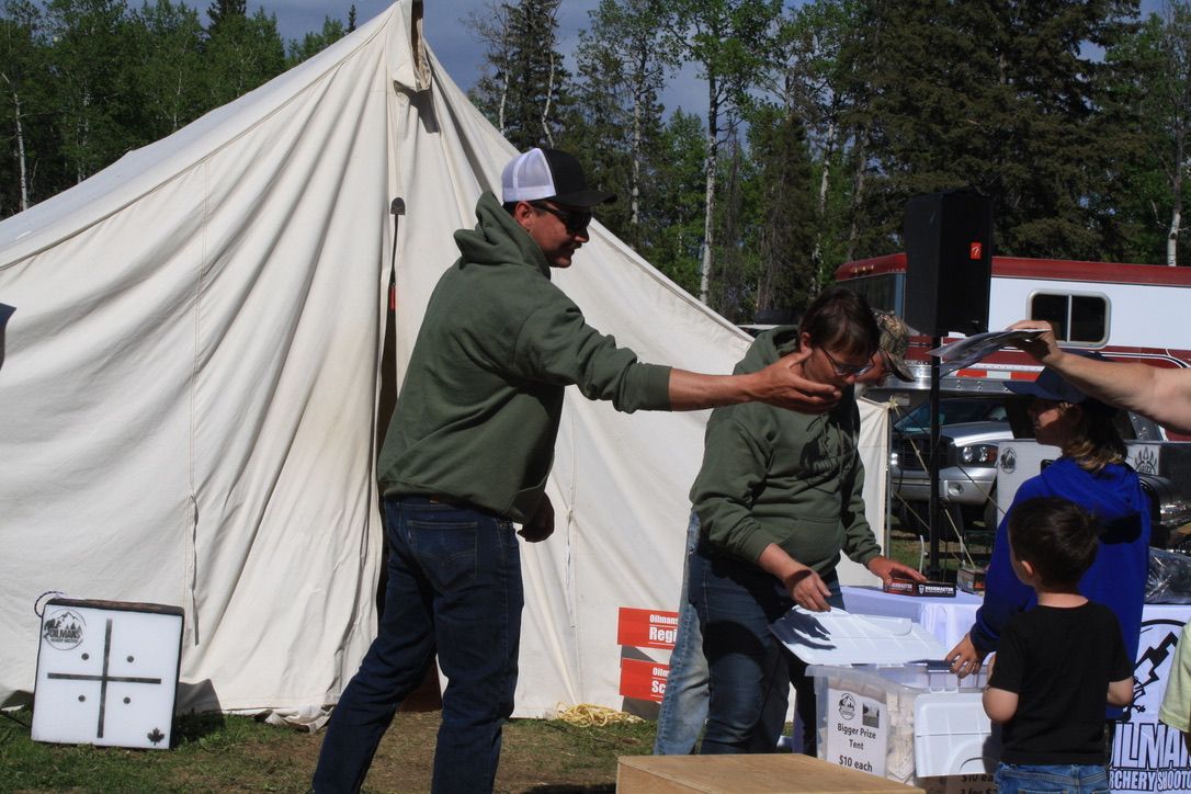 A group of people are standing in front of a tent.