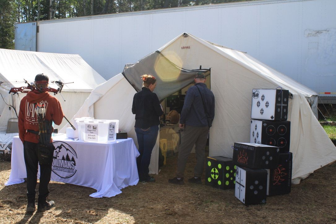 A group of people are standing in front of a tent