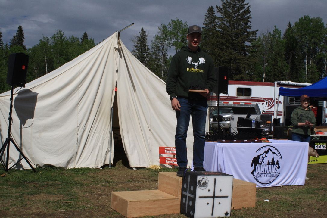 A man stands on a podium in front of a tent