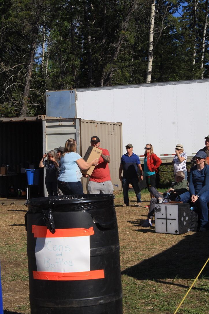 A group of people are standing around a large black barrel