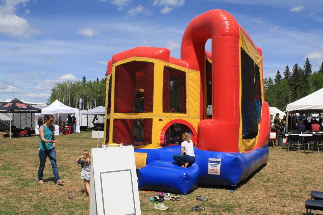 A red and yellow bouncy house is in the middle of a field.
