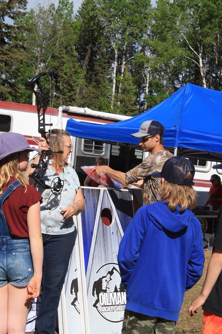 A group of people are standing under a blue tent.