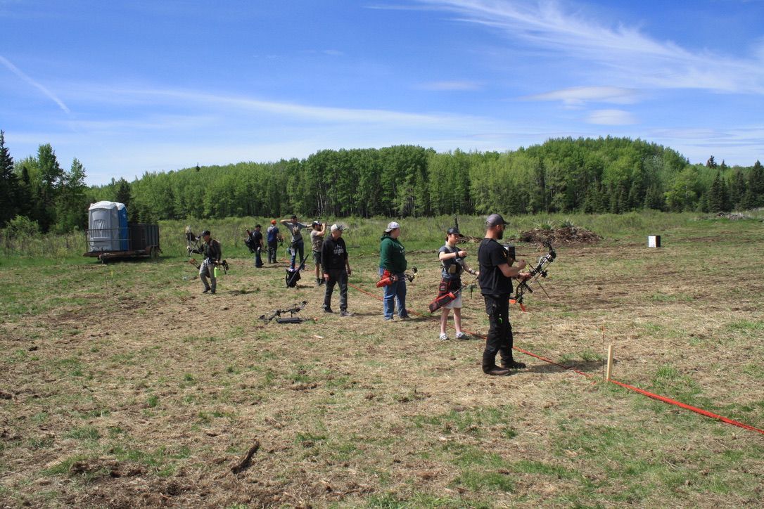 A group of people are standing in a field.