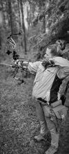 Archery shooting an arrow at a field target.