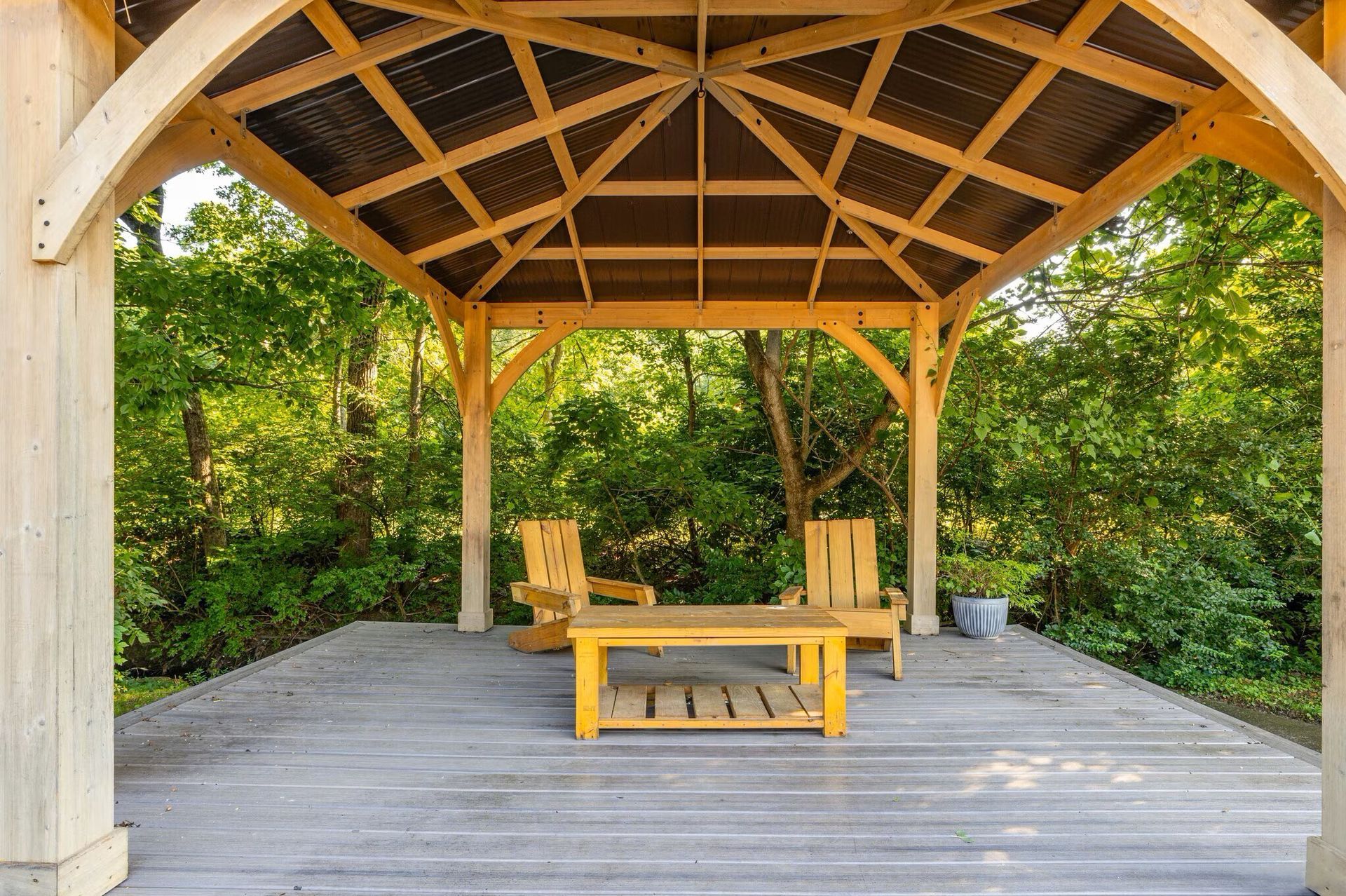 Glastonbury Woods Apartments Wooden gazebo with seating, overlooking a lush green backdrop.