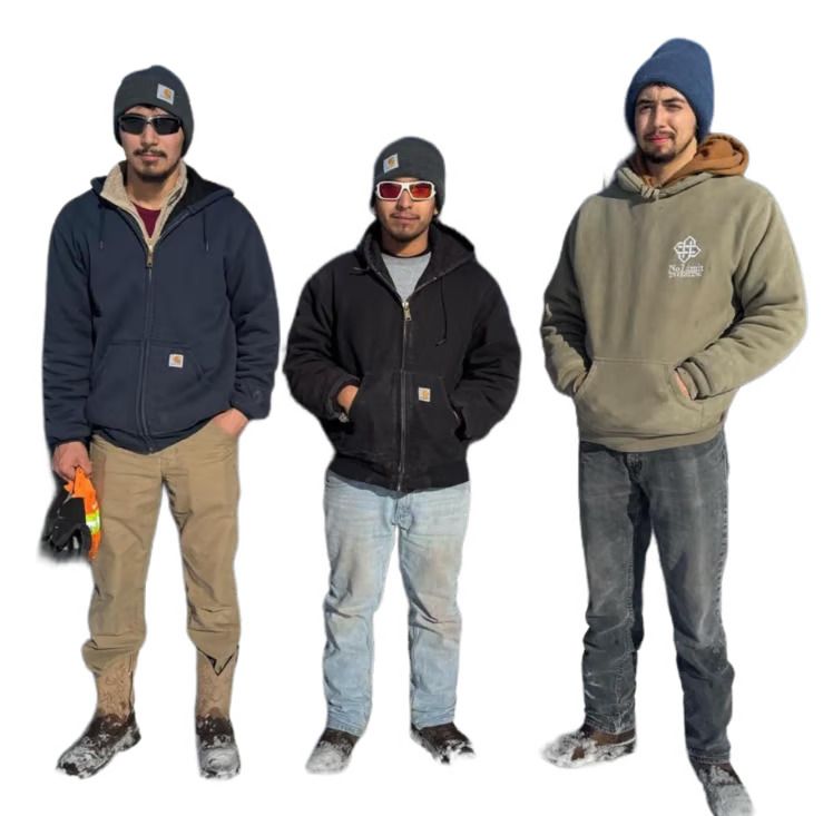Three men in winter workwear, wearing hats, jackets, and work boots, standing outside.