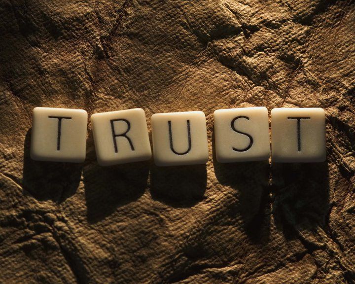 The word trust is spelled out in scrabble tiles