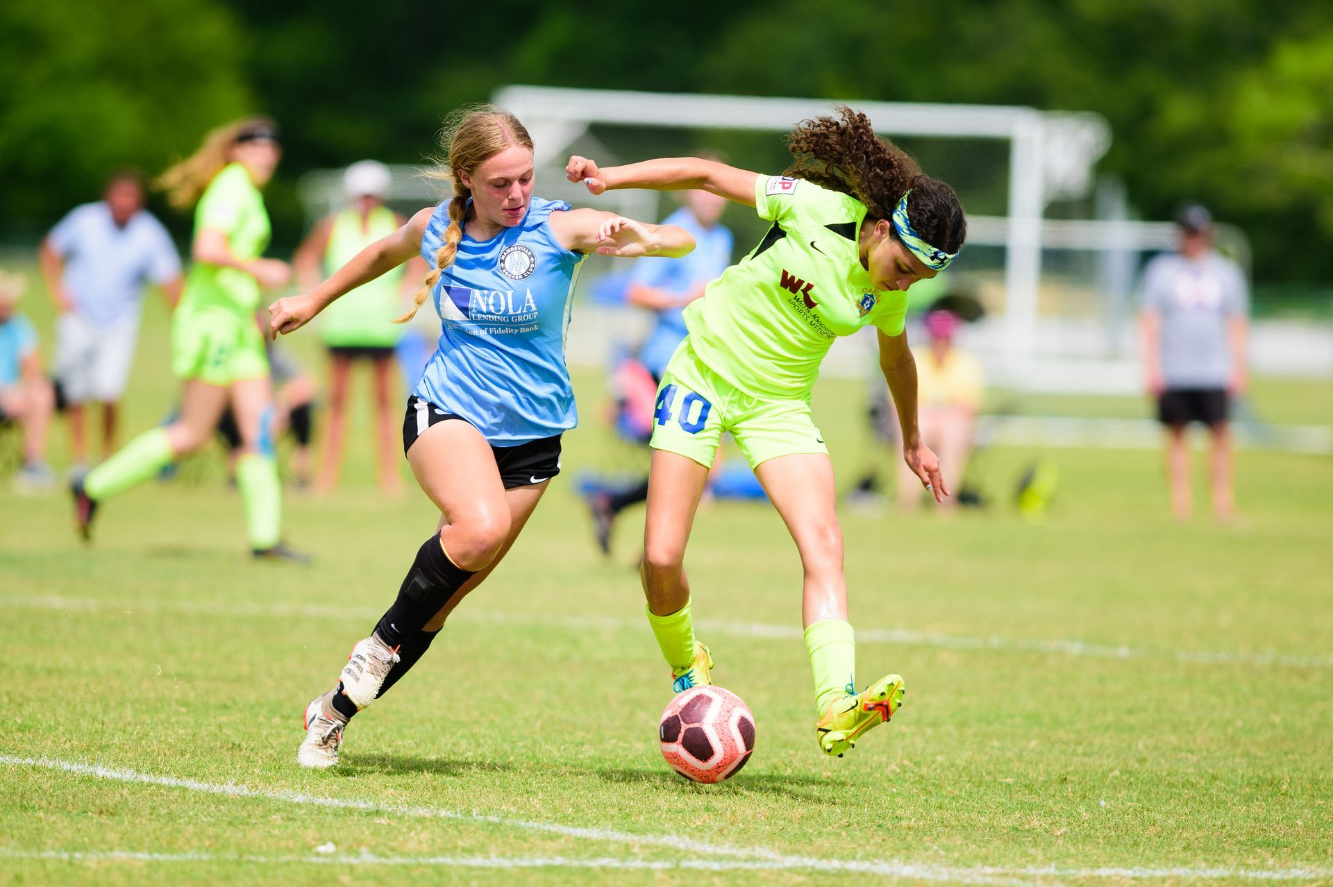 Two young female soccer players for Mandeville Soccer Club in a game