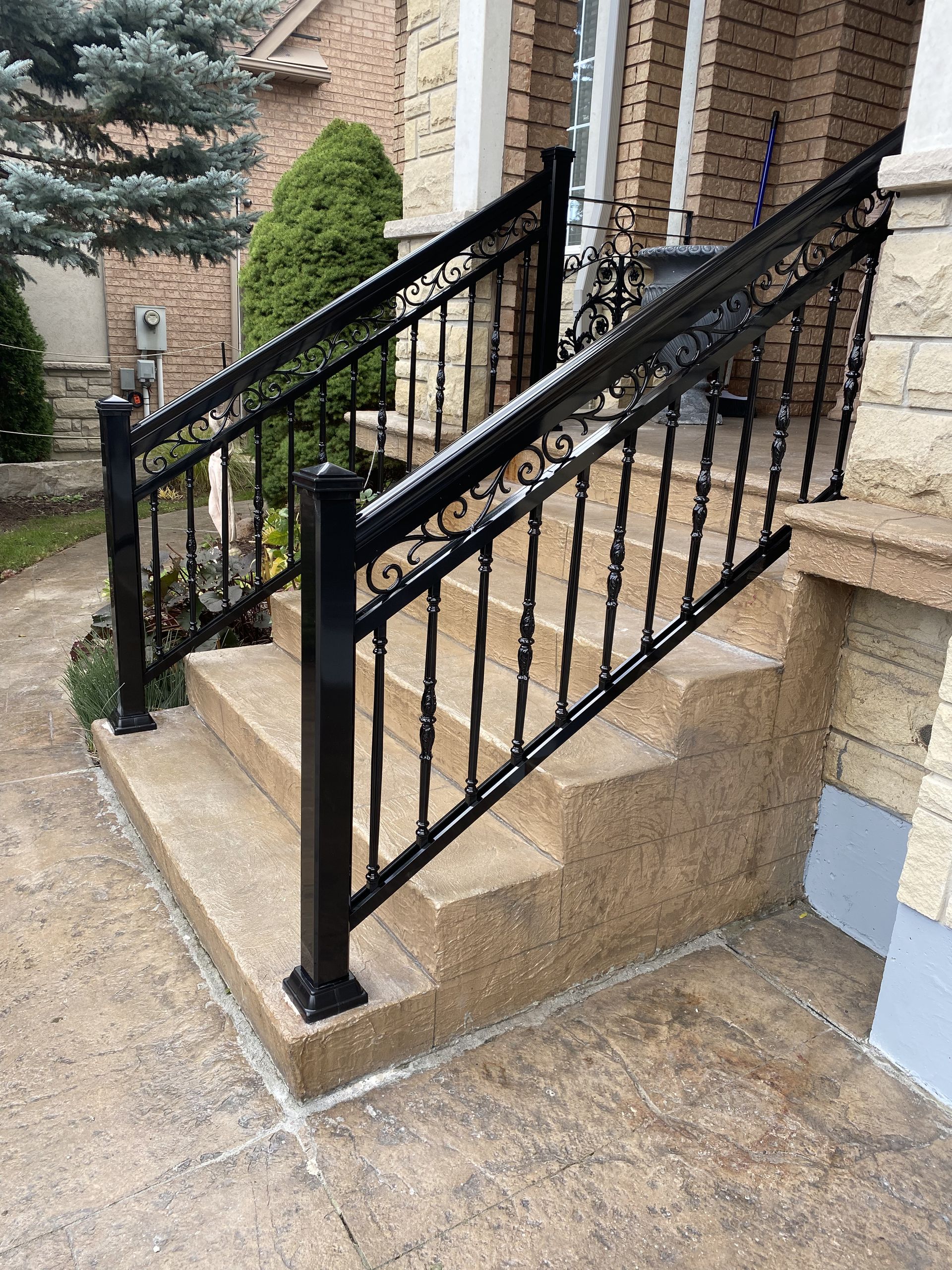 A wrought iron railing on the steps of a house.