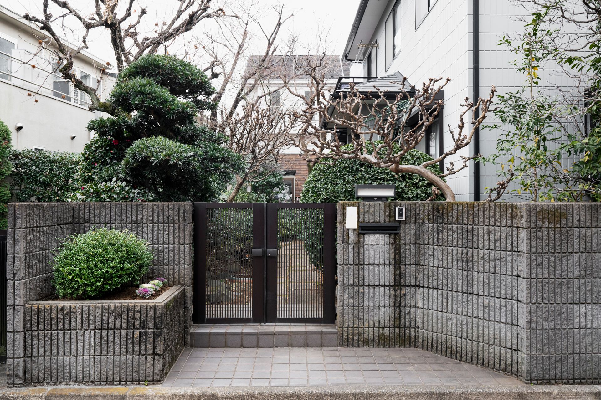 A house with a gate and a mailbox in front of it