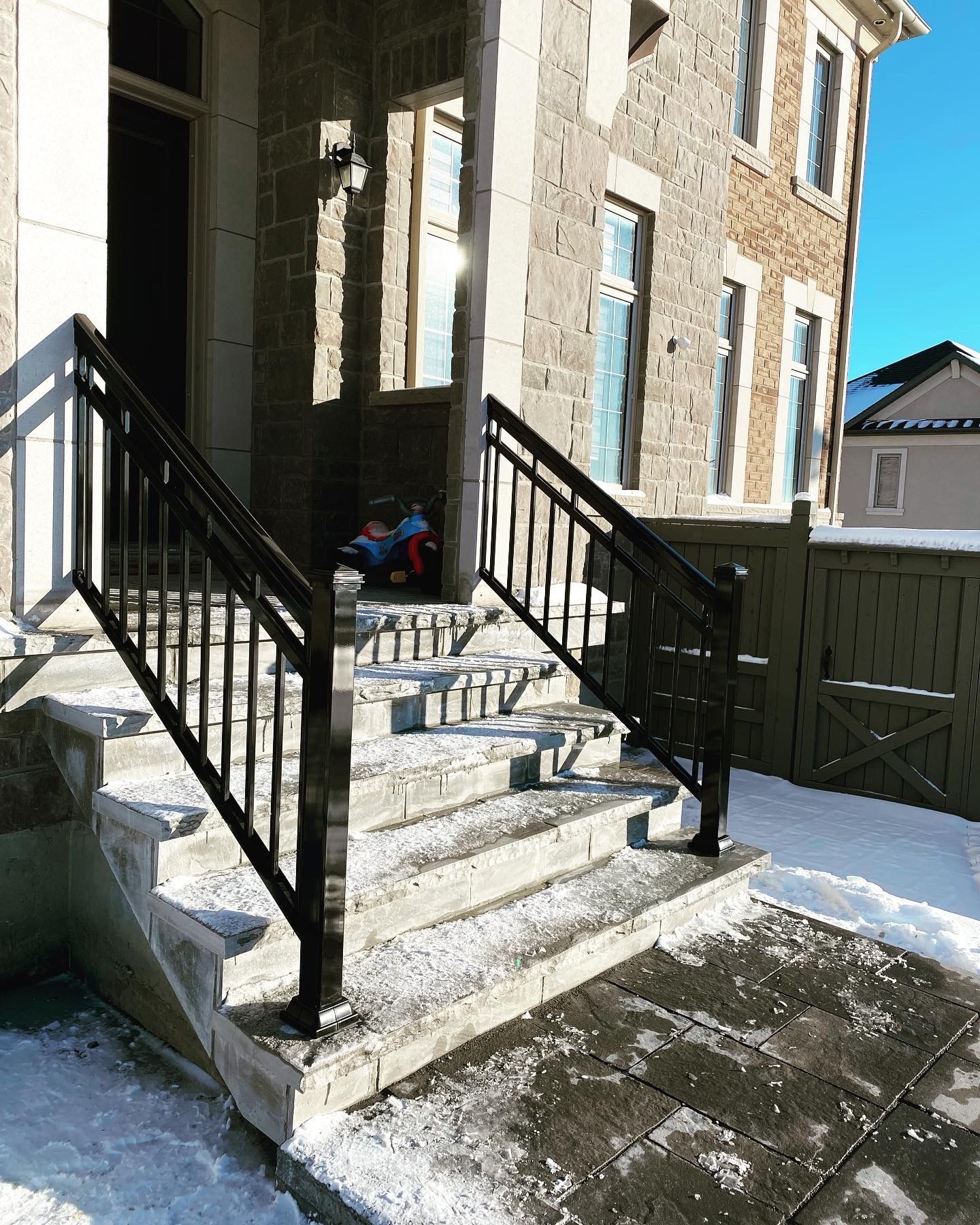 A child is sitting on the steps of a house.