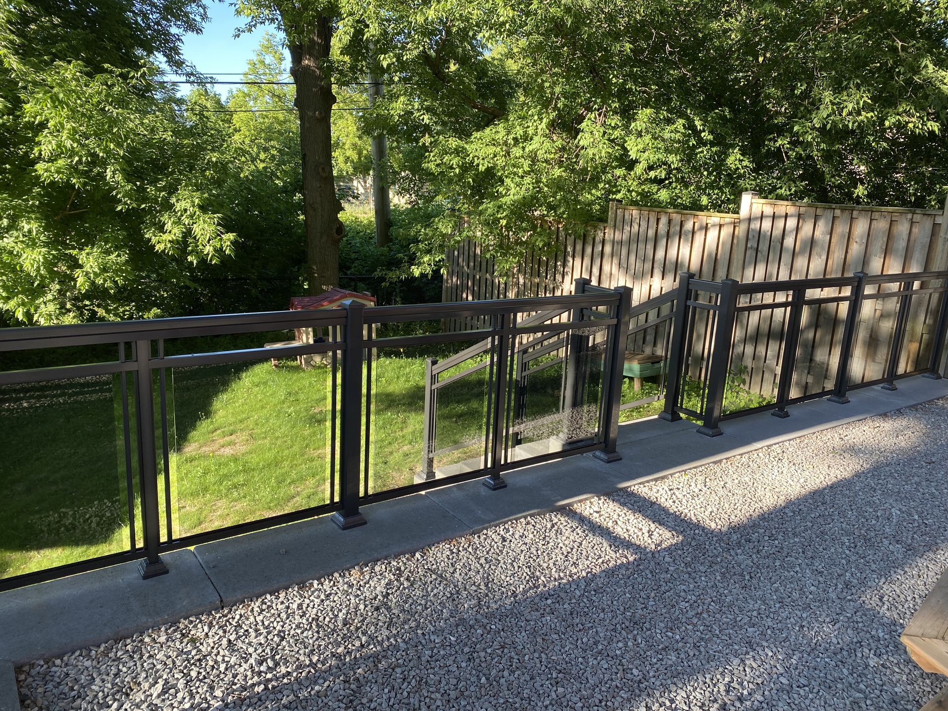 A balcony with a glass railing and a fence surrounding it.