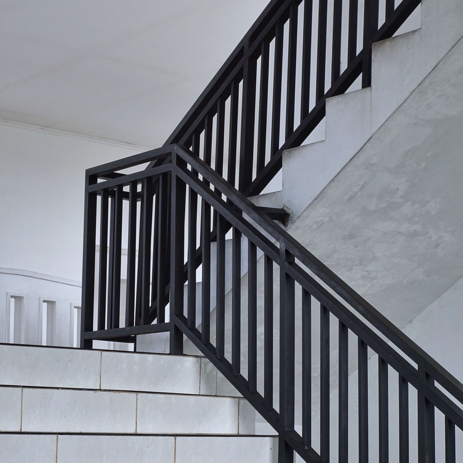 A staircase with a black railing and white steps