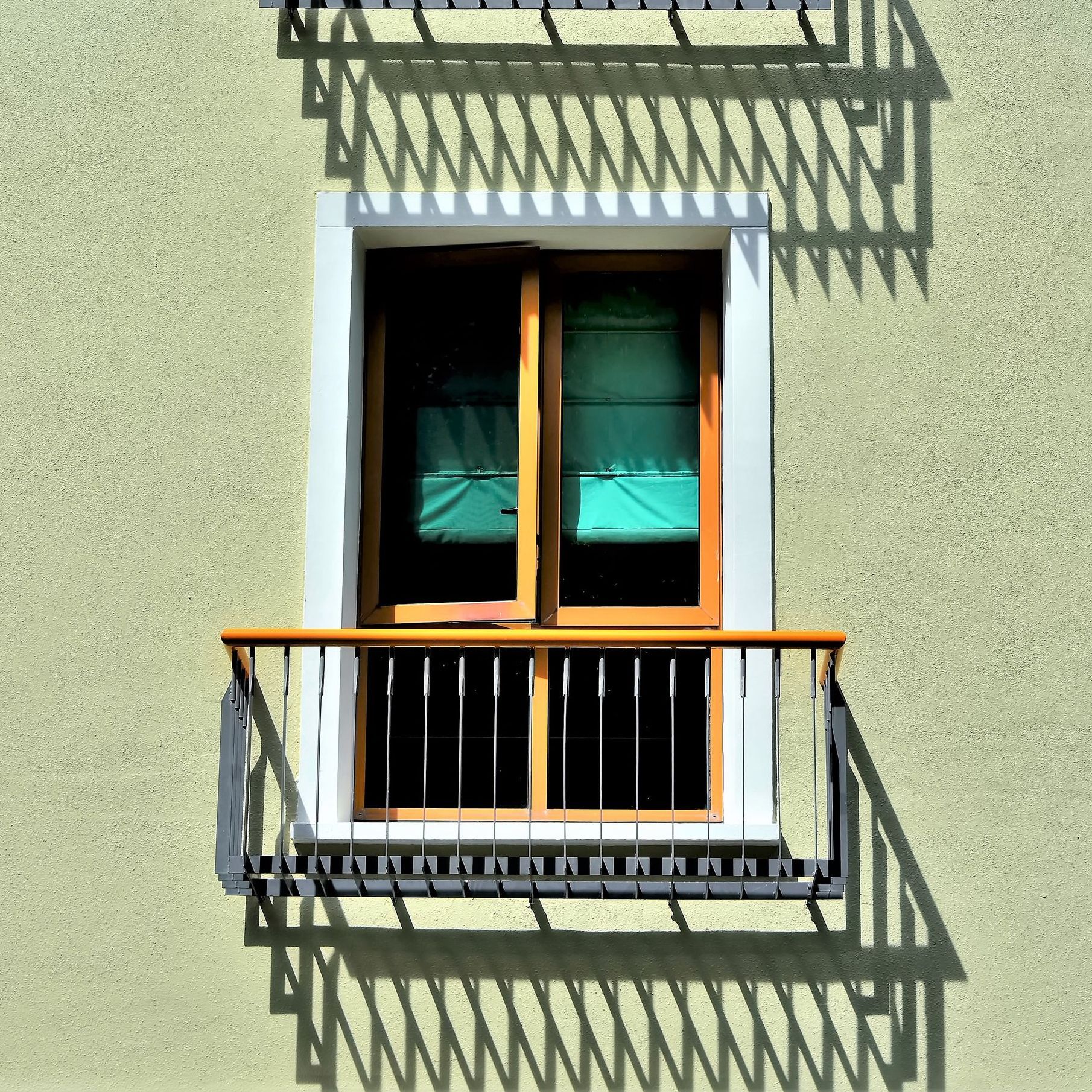 A window with a balcony on the side of a building