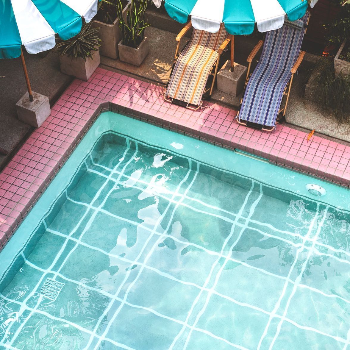 An aerial view of a swimming pool with chairs and umbrellas