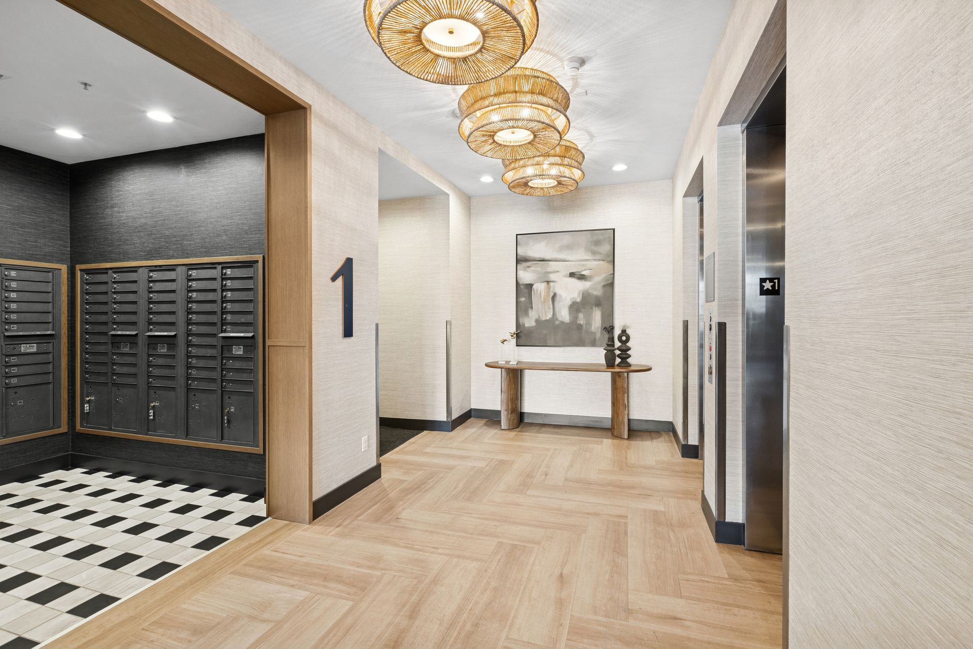 Modern apartment lobby with gold pendant lights, mailboxes, and herringbone wood flooring