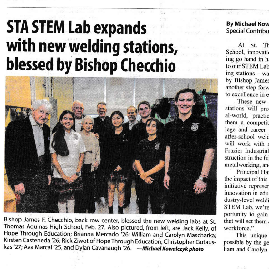 Group of people in a STEM lab with new welding stations, blessed by Bishop Checchio.