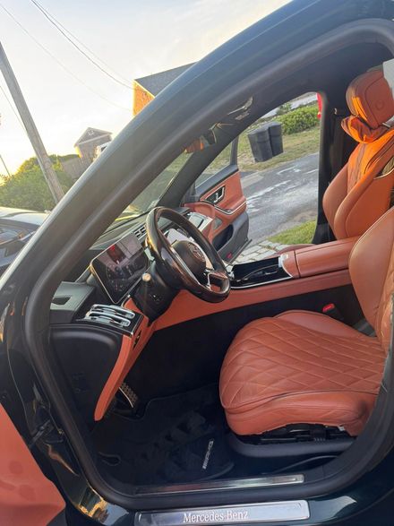 The interior of a luxury car with black trim and quilted brown leather seats.