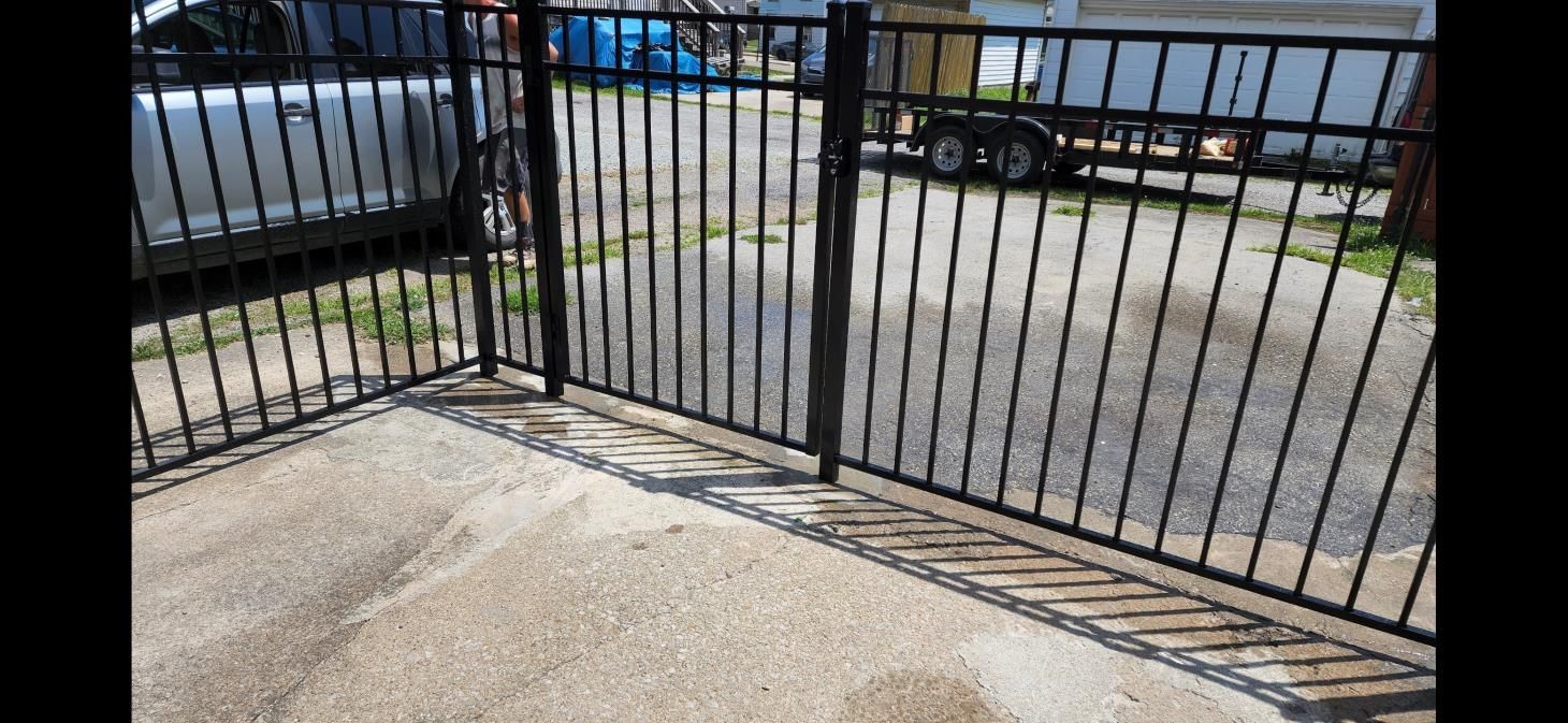 a person is using a drill on a green fence