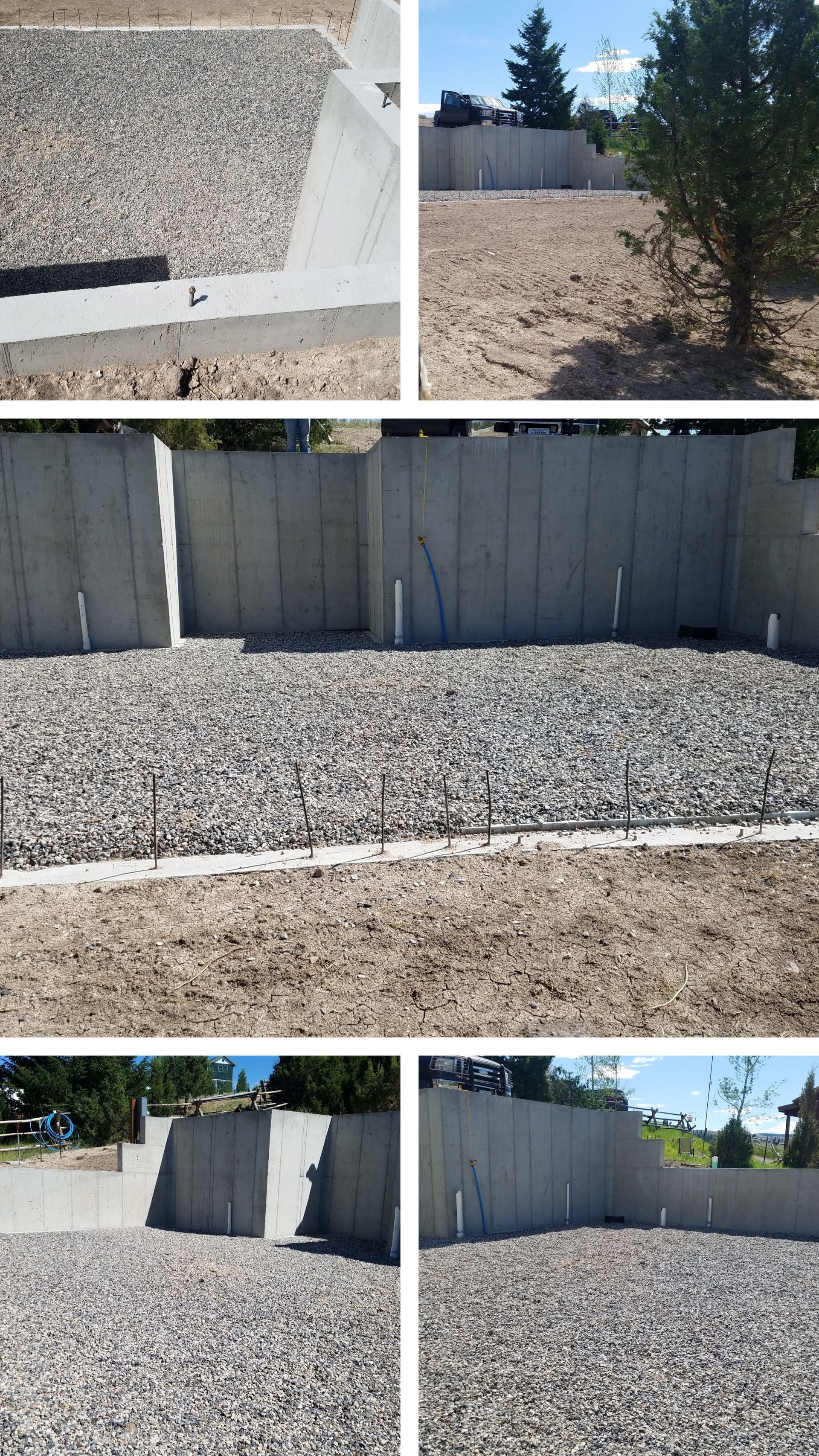 Rocks covering a yard beside a tall beige fence and evergreen trees under clear blue sky