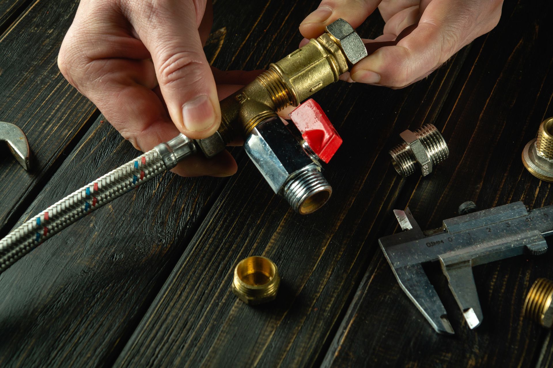 A person is working on a pipe on a wooden table.