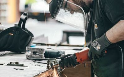 A man is using a grinder on a piece of metal.