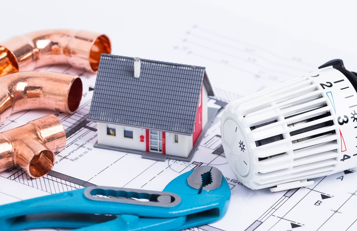 utensili idraulici e tubi di rame su progetti architettonici, che suggeriscono lavori di ristrutturazione