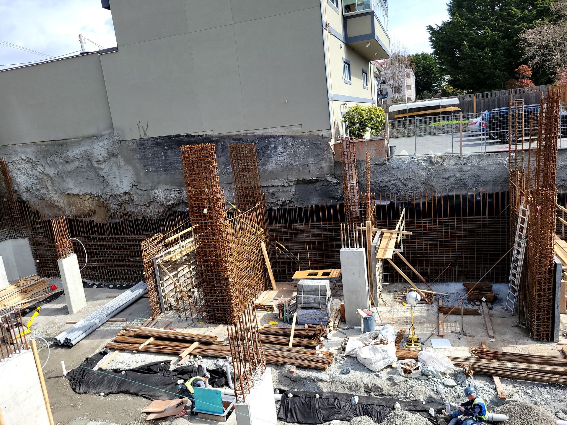 The foundation of a tall building is being created with concrete