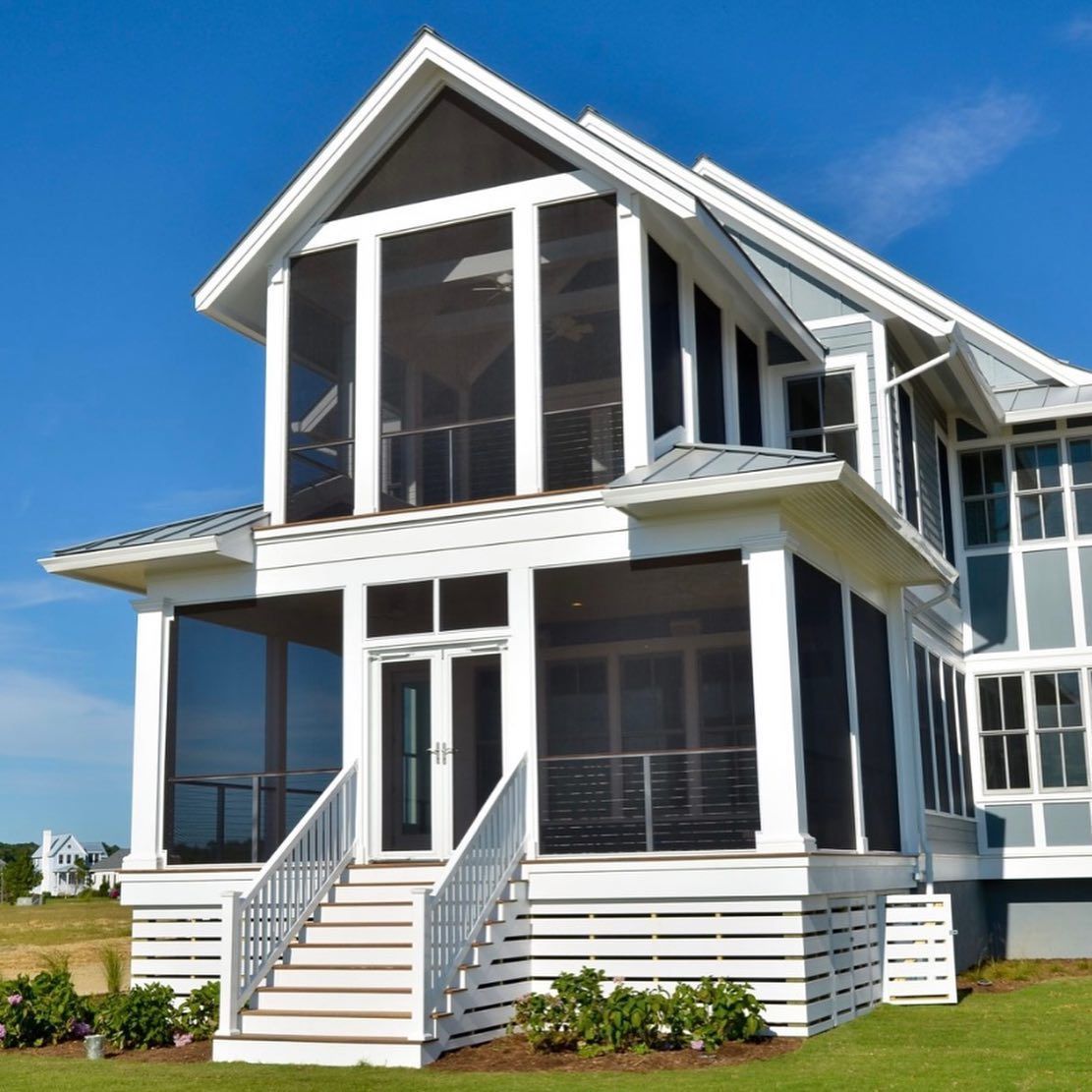 A white house with a screened in porch and stairs