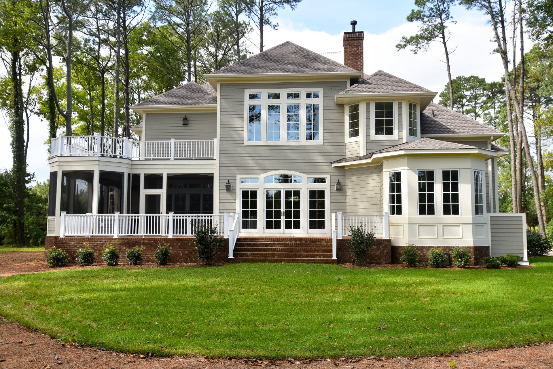 A white house with a screened in porch and stairs