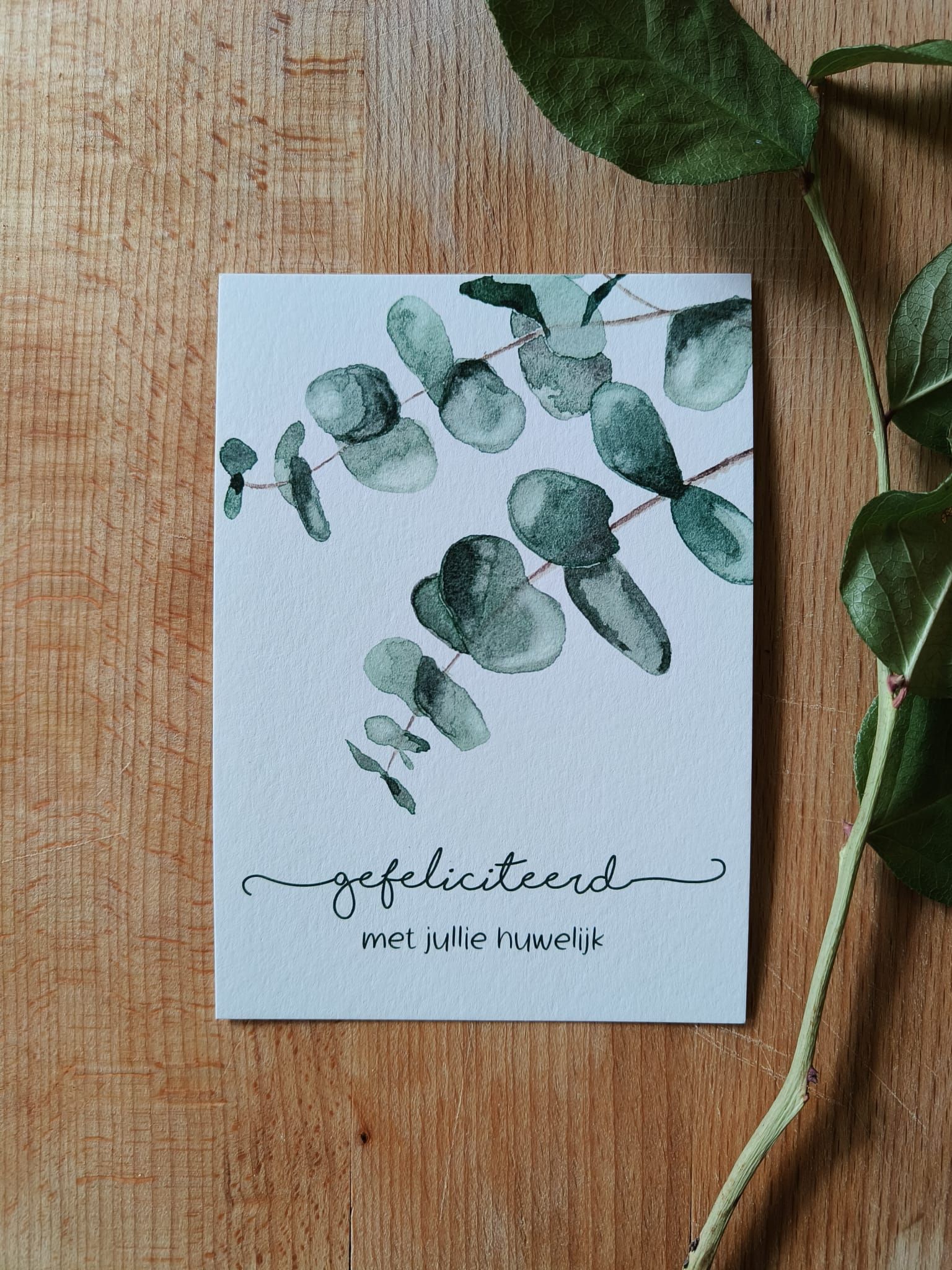 Kaart met eucalyptus illustratie en haar betekenis op een houten ondergrond.
