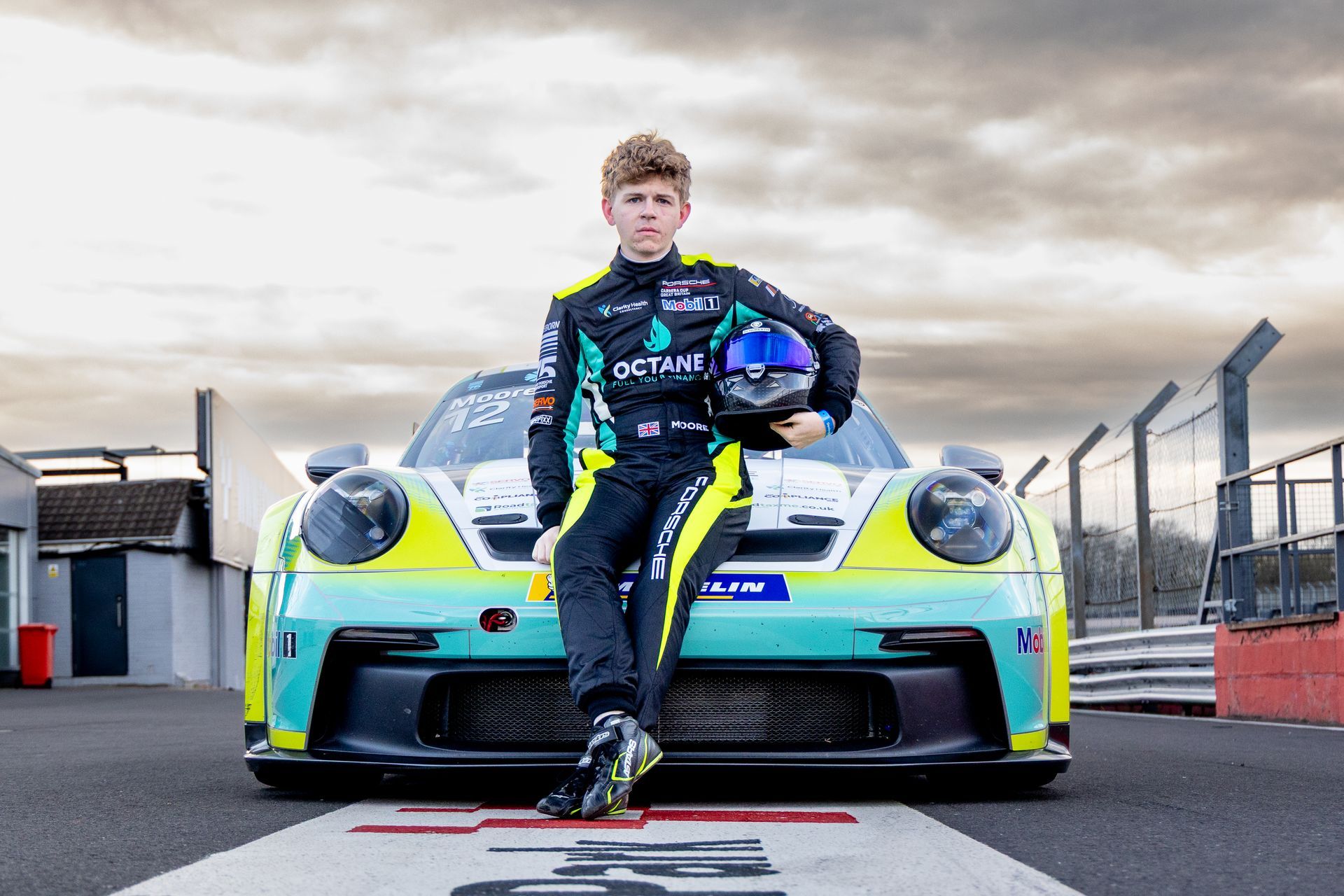 Jonny Moore sitting on porsche carrera cup car