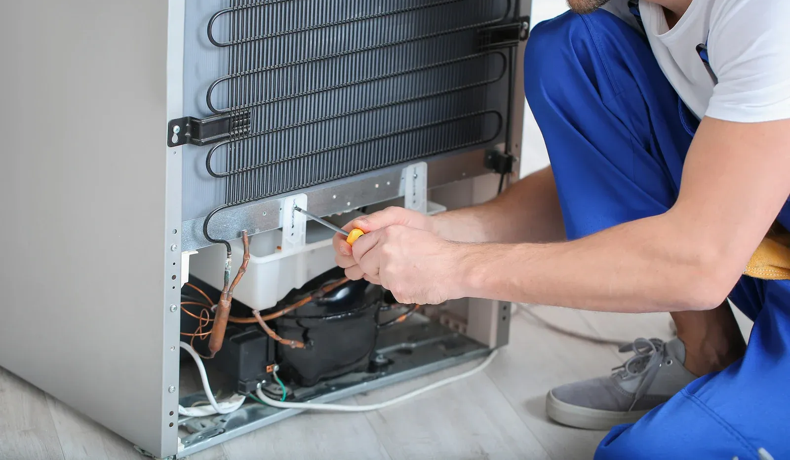 HVAC technician using a torch on rooftop unit, wearing safety gear.