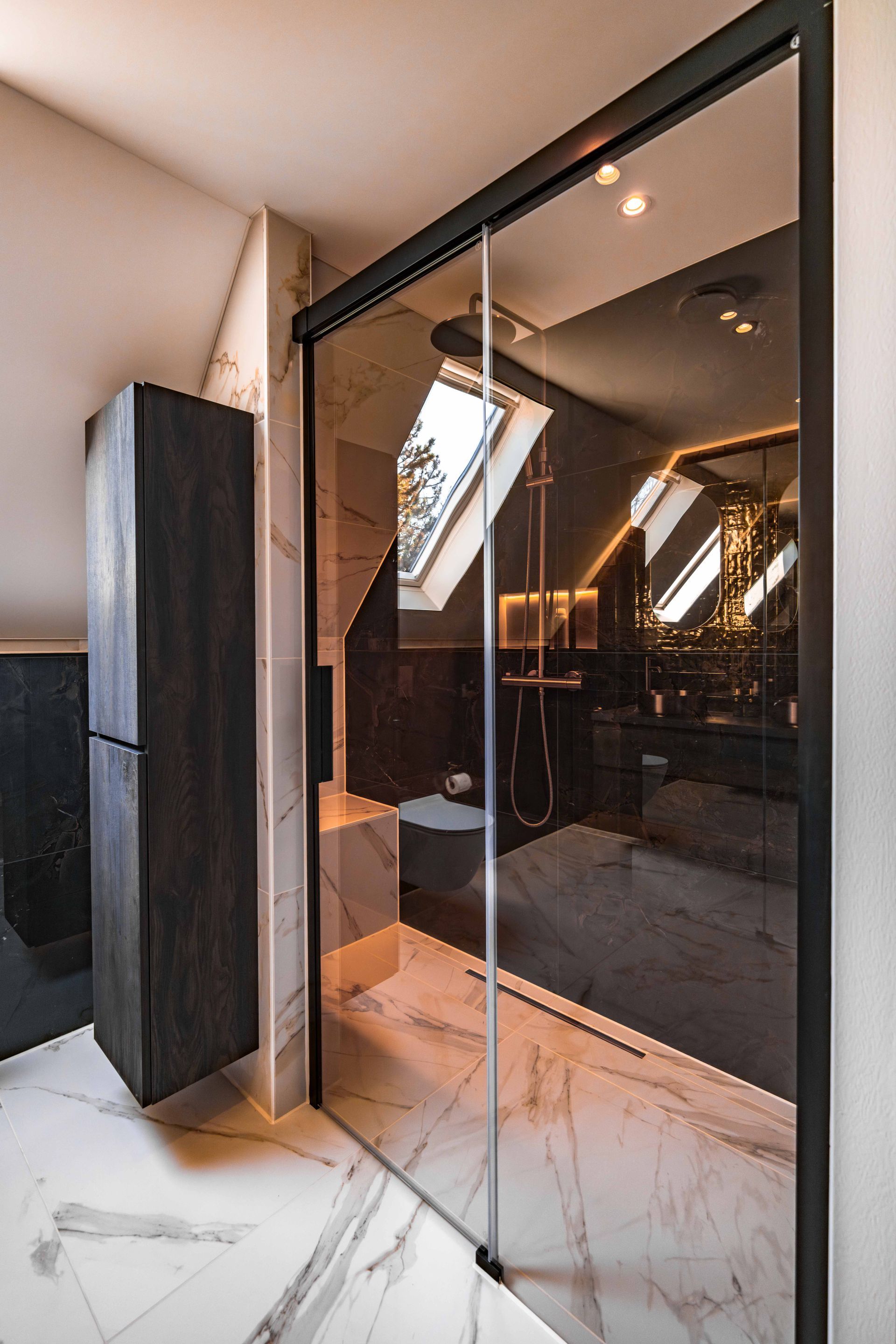 Glazen entree met marmeren vloer en zwarte omlijsting in een modern interieur.